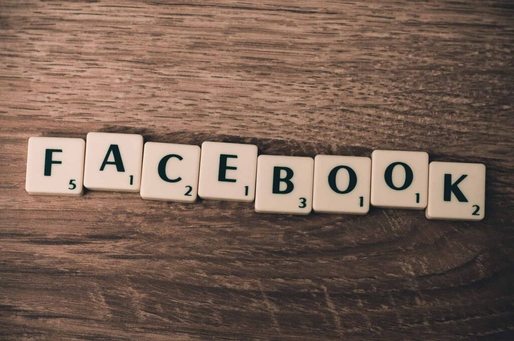 the word facebook spelled out with scrabble blocks on a wooden table